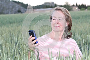 Mature woman using cellphone in nature