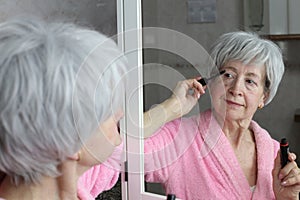 Mature woman using mascara for her lashes