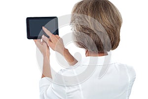 Mature woman using tablet, from back.