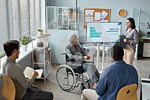 Mature woman using wheelchair in business meeting