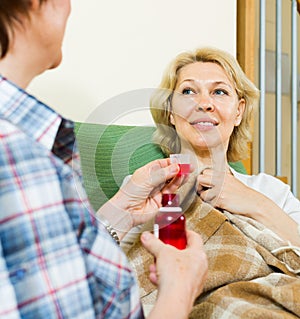 Mature woman visiting sick friend