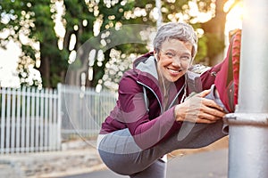 Mature woman warming up before jogging