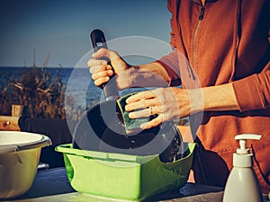 Woman washing dishes in bowl, capming outdoor photo