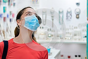 Mature woman wearing face protective mask while buying presents in a shop.