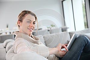 Mature woman websurfing with tablet at home photo