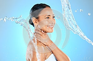 Mature woman, wet or water splash on blue background in studio skincare wellness, hygiene maintenance or body cleaning