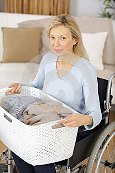 mature woman in wheelchair with laundry basket