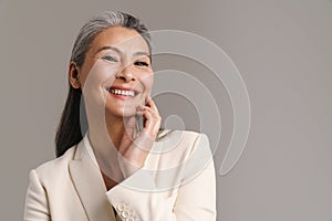 Mature woman with white hair smiling and looking at camera