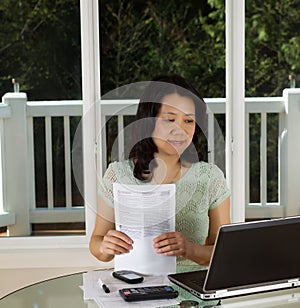 Mature woman working at home office with tax forms