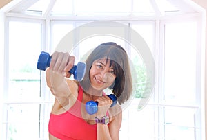 Mature woman working out with dumbbells