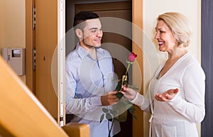 Mature woman and young guy at doorway