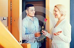 Mature woman and young guy at doorway