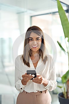 Mature business woman worker using cell phone in office, vertical portrait.