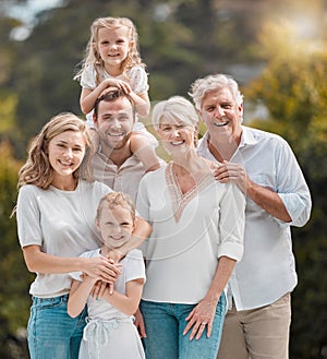 Mature and young family members outside in the garden. Happy smiling parents relaxing outside with their children