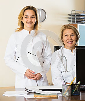 Mature and young female doctors in clinic