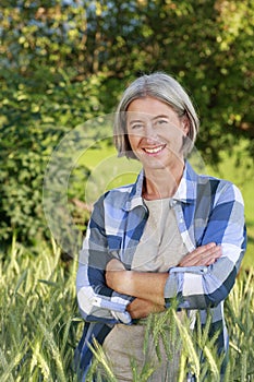 Matured farm woman in front of a cornfield