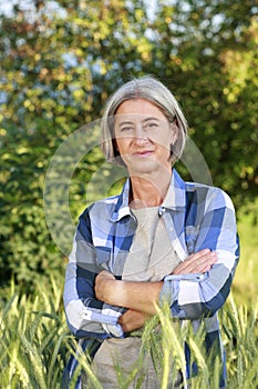 Matured farm woman in front of a cornfield