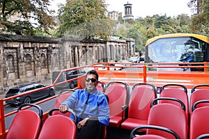 Matured Indian Man Sitting on an Open Deck Tourist Sightseeing Bus