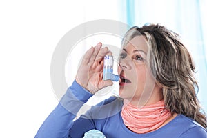 Matured woman inhales asthma spray