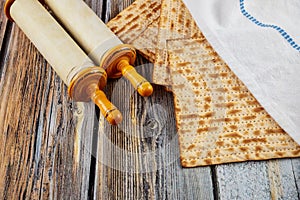 Matzah, tallit and torah on wooden background