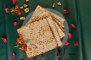 Matzo bread stack with nuts, flowers on table, creative arts display