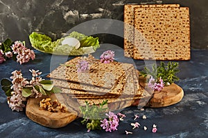 Matzo stack on wooden board with flowers, walnuts for floral design