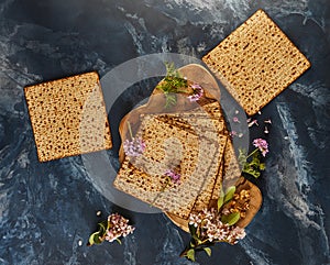 Matzo stack on wooden board with flowers, walnuts for floral design