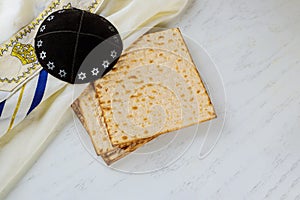 Matzo, tallit and kippa on white background