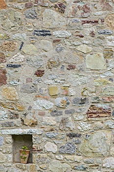 Mauer aus Naturstein mit Pflanzentopf im Hochformat in Italien photo