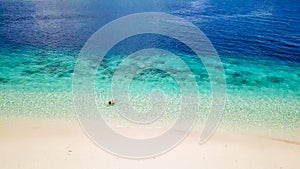 Maumere - A drone shot of a girl playing on the white sand beach