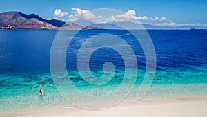 Maumere - A drone shot of a girl playing on the white sand beach photo