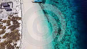 Maumere - A drone shot of an idyllic beach with a boat anchored on the shore