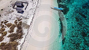 Maumere - A drone shot of an idyllic beach with a boat anchored on the shore