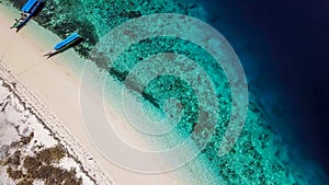 Maumere - A drone shot of a small island and the boats anchored to ist shore