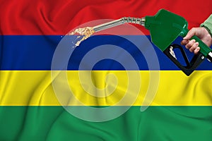 MAURITIUS flag Close-up shot on waving background texture with Fuel pump nozzle in hand. The concept of design solutions. 3d