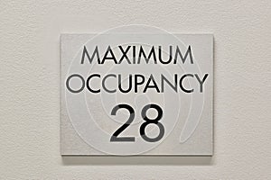Maximum Occupancy sign on a white interior wall in a commercial building.