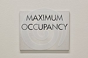 Maximum Occupancy sign on a white interior wall in a commercial building.