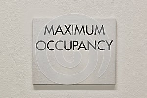 Maximum Occupancy sign on a white interior wall in a commercial building. photo