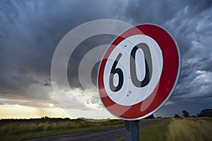 Maximum speed road sign with a stormy