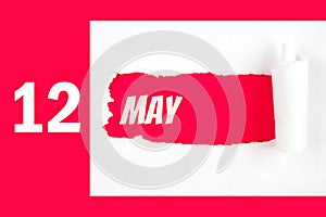 May 12nd. Day 12 of month, Calendar date. Red Hole in the white paper with torn sides with calendar date. Spring month, day of the