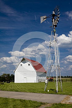 MAY 17, 2019, JEFFERSON CITY, MO USA - White barn with red roof and windmill along highway 100 outside of Jefferson City, MO