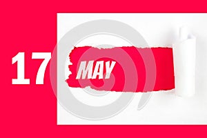 May 17th. Day 17 of month, Calendar date. Red Hole in the white paper with torn sides with calendar date. Spring month, day of the