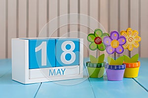 May 18th. Image of may 18 wooden color calendar on white background with flowers. Spring day, empty space for text