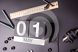 May 1st. Day 1 of may month, calendar on black background with workers tools. Labor day