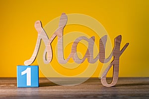 May 1st. Day 1 of may month, calendar on yellow background with wooden carved letters. Spring time