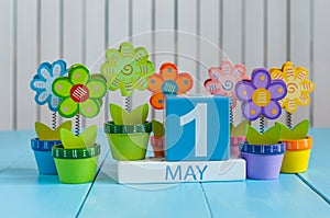 May 1st. Image of may 1 wooden color calendar on white background with flowers. Spring day, empty space for text