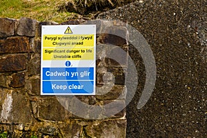 May 2021 sign in welsh and English unstable cliffs, keep clear. Aftermath of huge cliff landslip at Nefyn, Llyn Peninsula, Wales