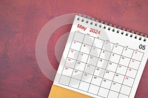 May 2024 desk calendar on red background