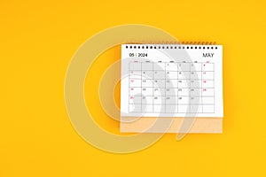 May 2024 desk calendar on yellow color background, position with copy space