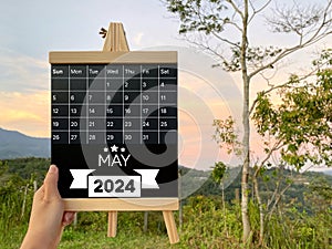 May 2024 monthly calendar concept on whiteboard with nature background. Stock photo.